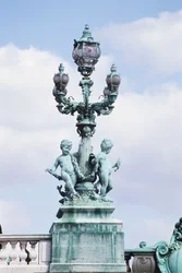 Francja, Paryż, metalowy posąg nagich dzieci na Pont Alexander III, zdobiona latarnia z rzeźbami.